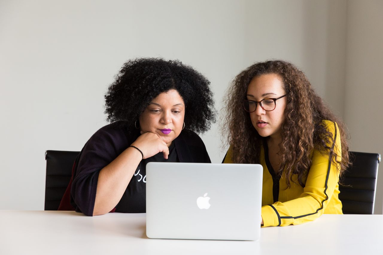 ead-como-ferramenta-de-inclusao - duas mulheres sentadas lado a lado olhando para tela de notebook curiosas