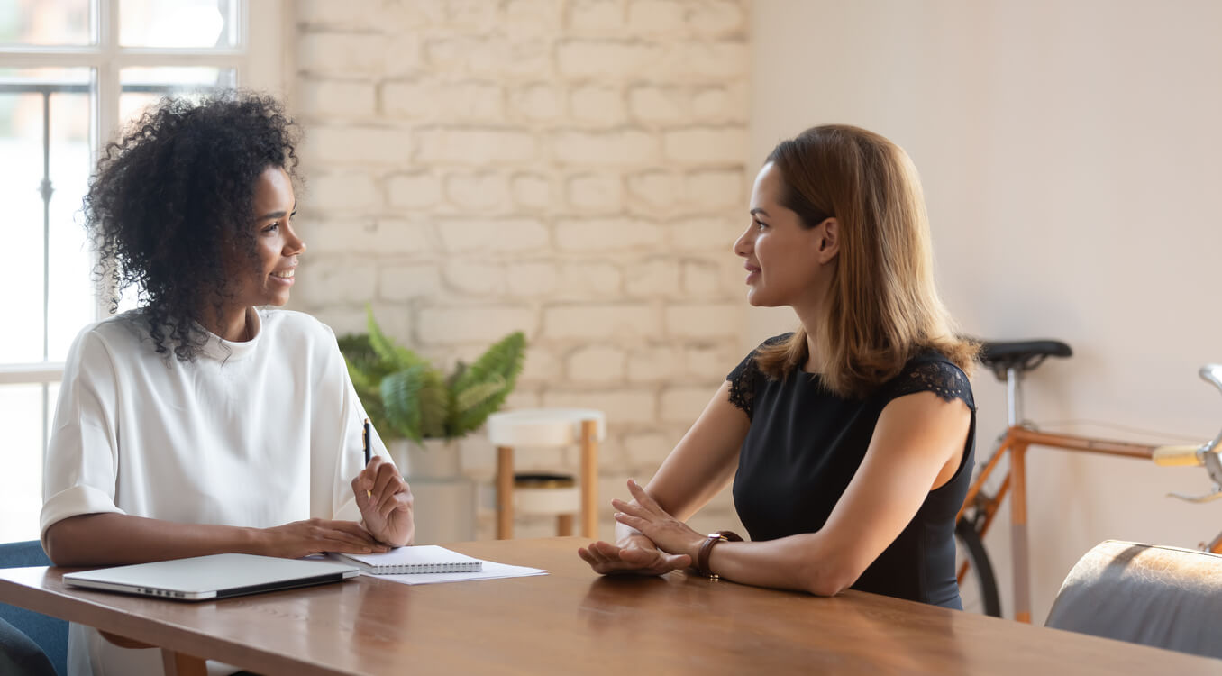 modelo de curriculum vitae - duas mulheres conversando em entrevista de emprego